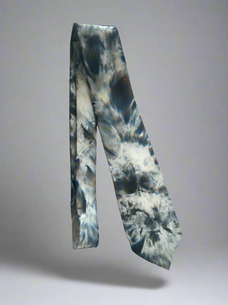 Tie with a blue and gray tie-dye pattern on a light gray background