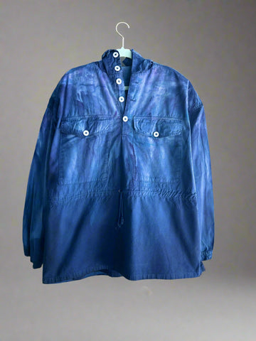 Blue shirt on a hanger against a white brick wall